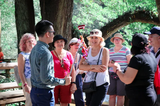 Phudit talking with travelers during an outdoor visit
