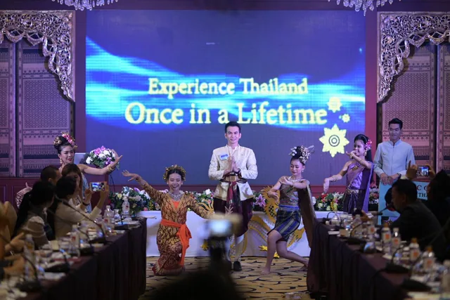 Phudit on stage with performers at a Thai cultural event