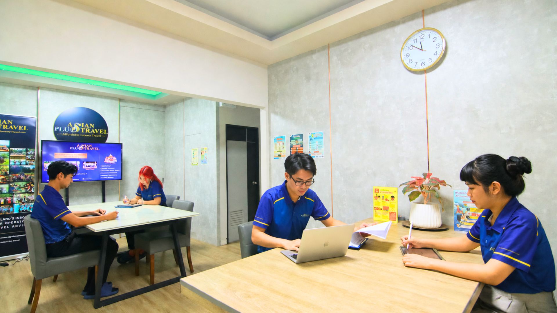 Team members working together with a laptop and trip documents